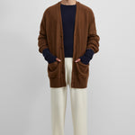 man wearing cream rib-knit cashmere pants with a drawstring waistband and straight legs.