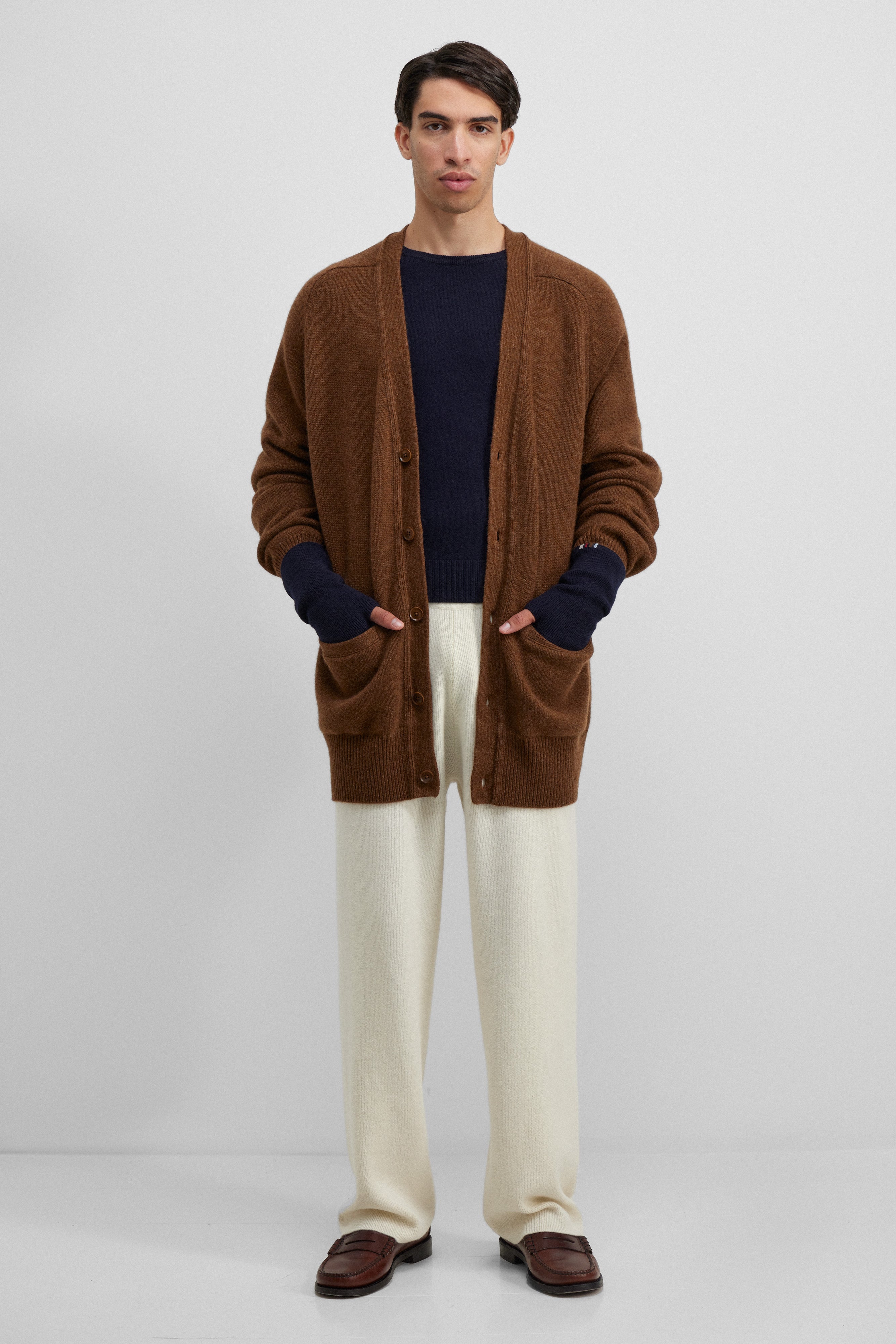 man wearing cream rib-knit cashmere pants with a drawstring waistband and straight legs.