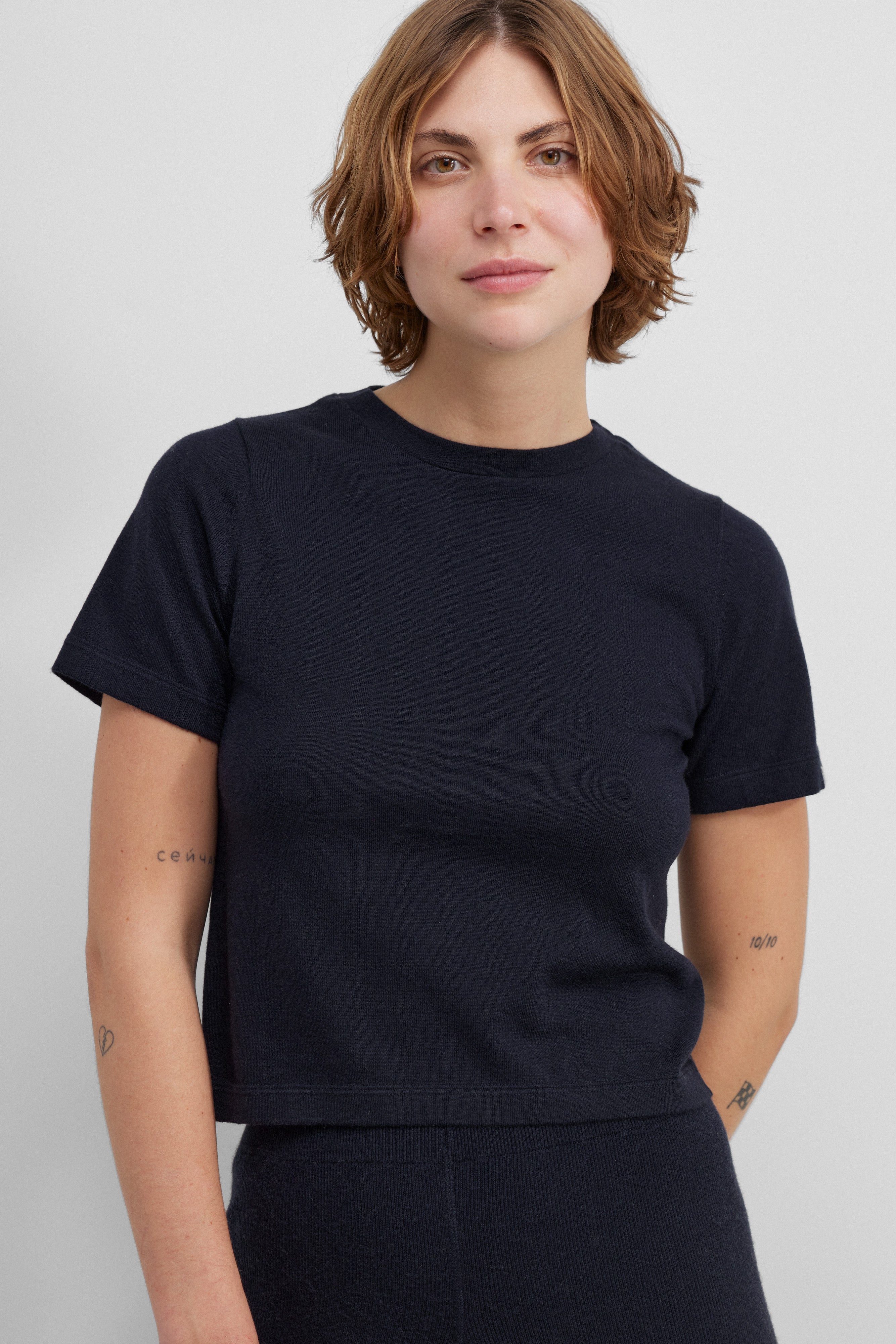 woman wearing a navy blue cropped short-sleeved cotton cashmere crewneck t-shirt.