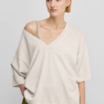woman wearing an oversized cotton cashmere v-neck t-shirt with elbow-length sleeves.