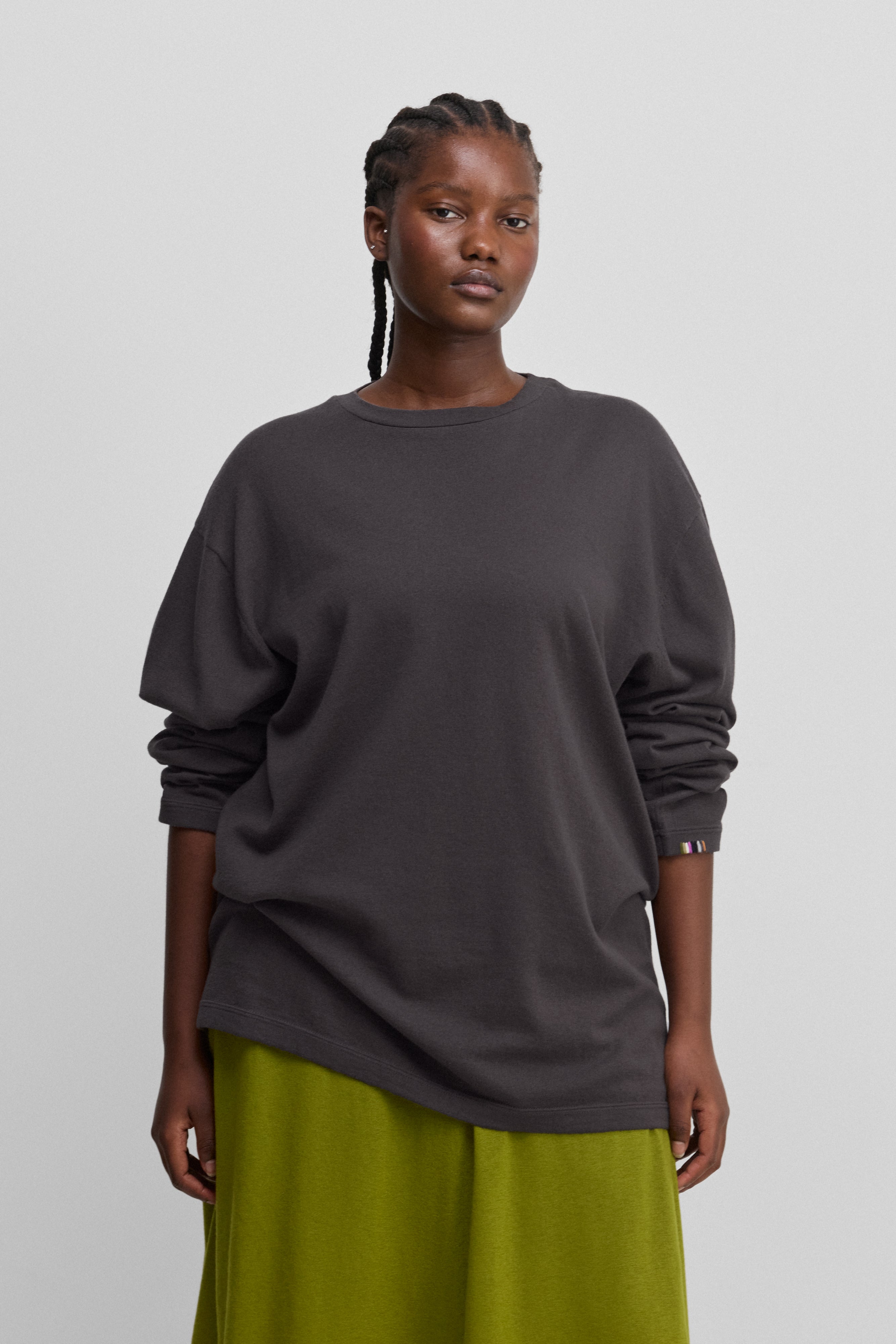woman wearing a dark grey oversized long-sleeved cotton-cashmere t-shirt with a round neckline.