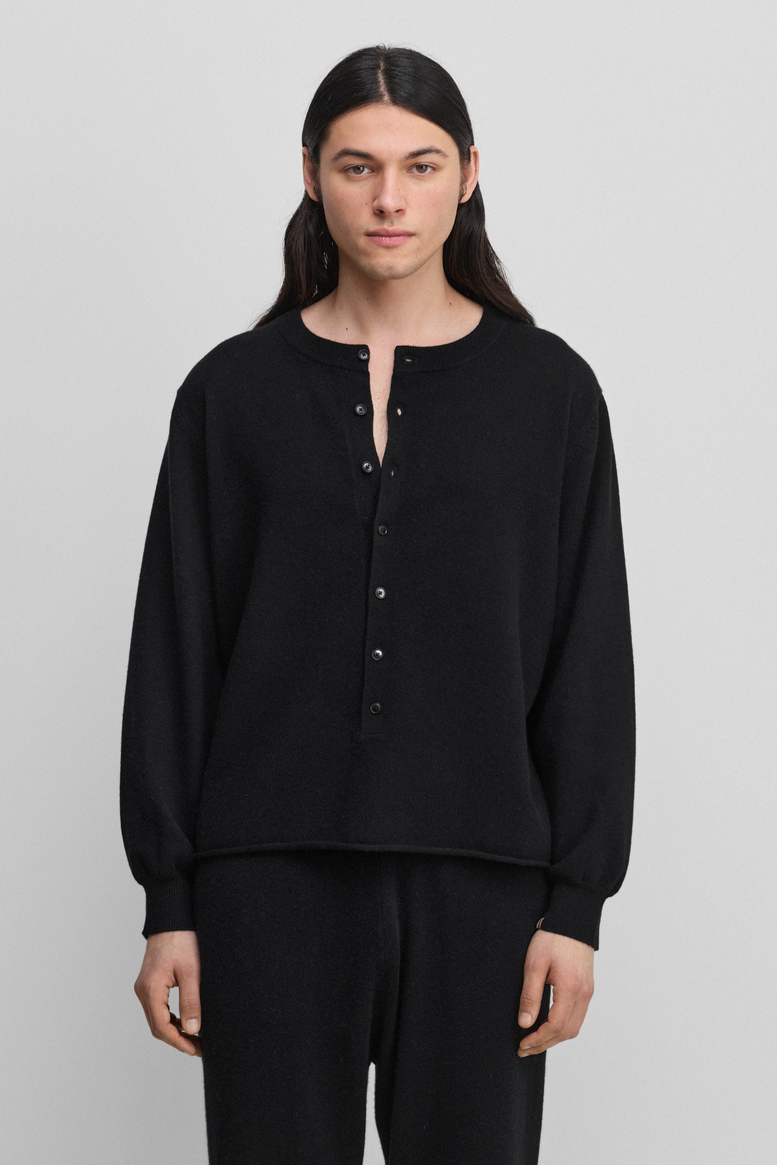 man wearing a black cashmere sweater with corozo buttons.