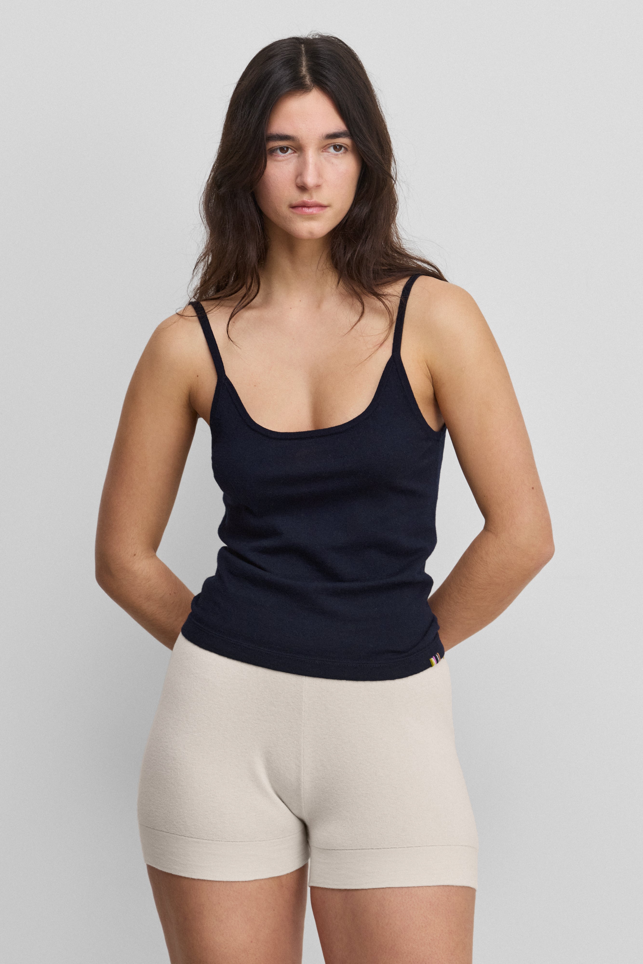 woman wearing a black fitted cotton cashmere strap top with a round neckline.