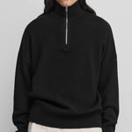 man wearing a black quarter-zip cashmere sweater with drop shoulder and ribbed hem and cuffs.