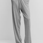 woman wearing loose-fit grey cotton cashmere pants with side pockets and drawstring waist.