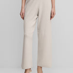 woman wearing white rib-knit cashmere pants with straight legs and a drawstring waist.