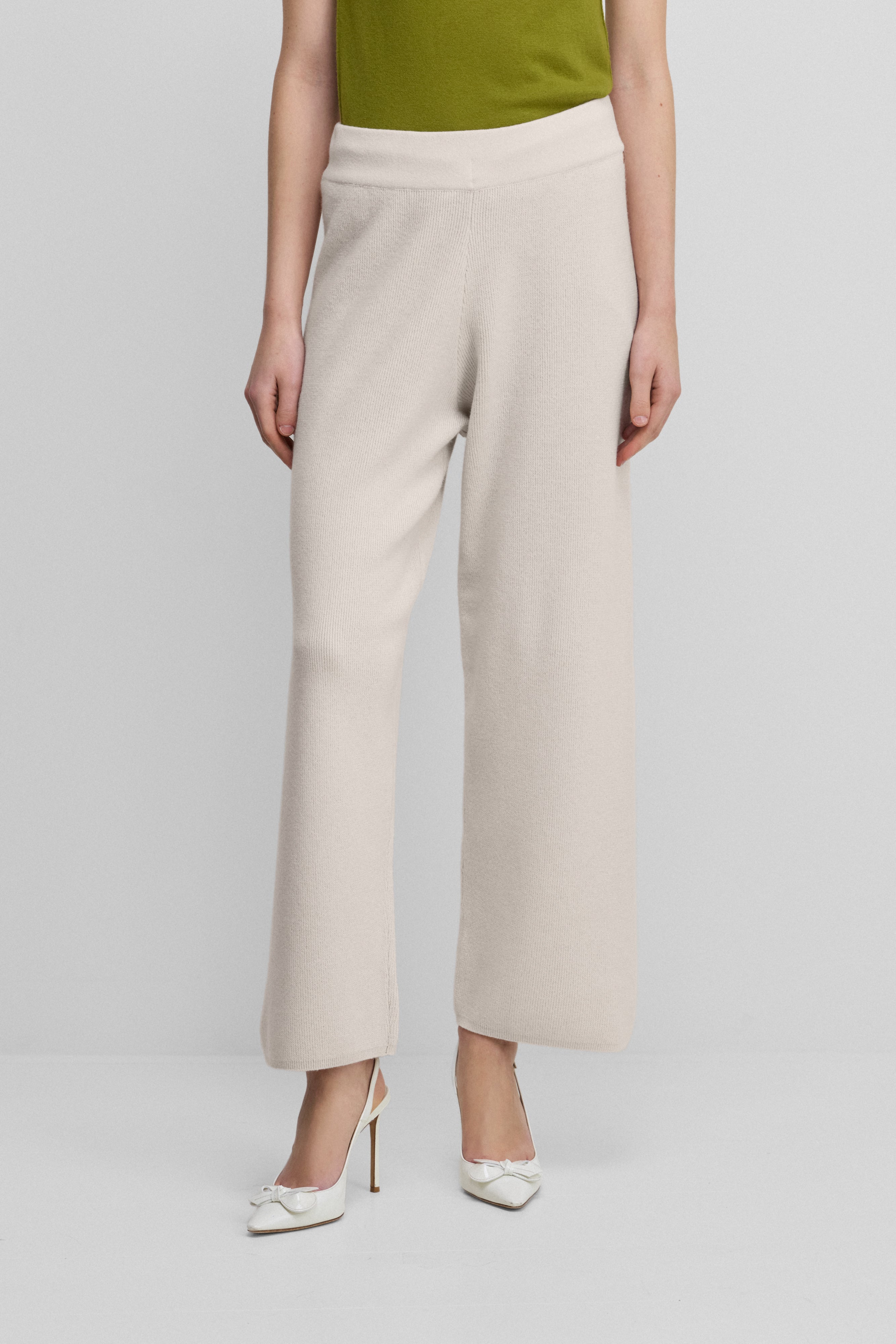 woman wearing white rib-knit cashmere pants with straight legs and a drawstring waist.