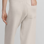 woman wearing white rib-knit cashmere pants with a drawstring waist and one back pocket, shown from the back.
