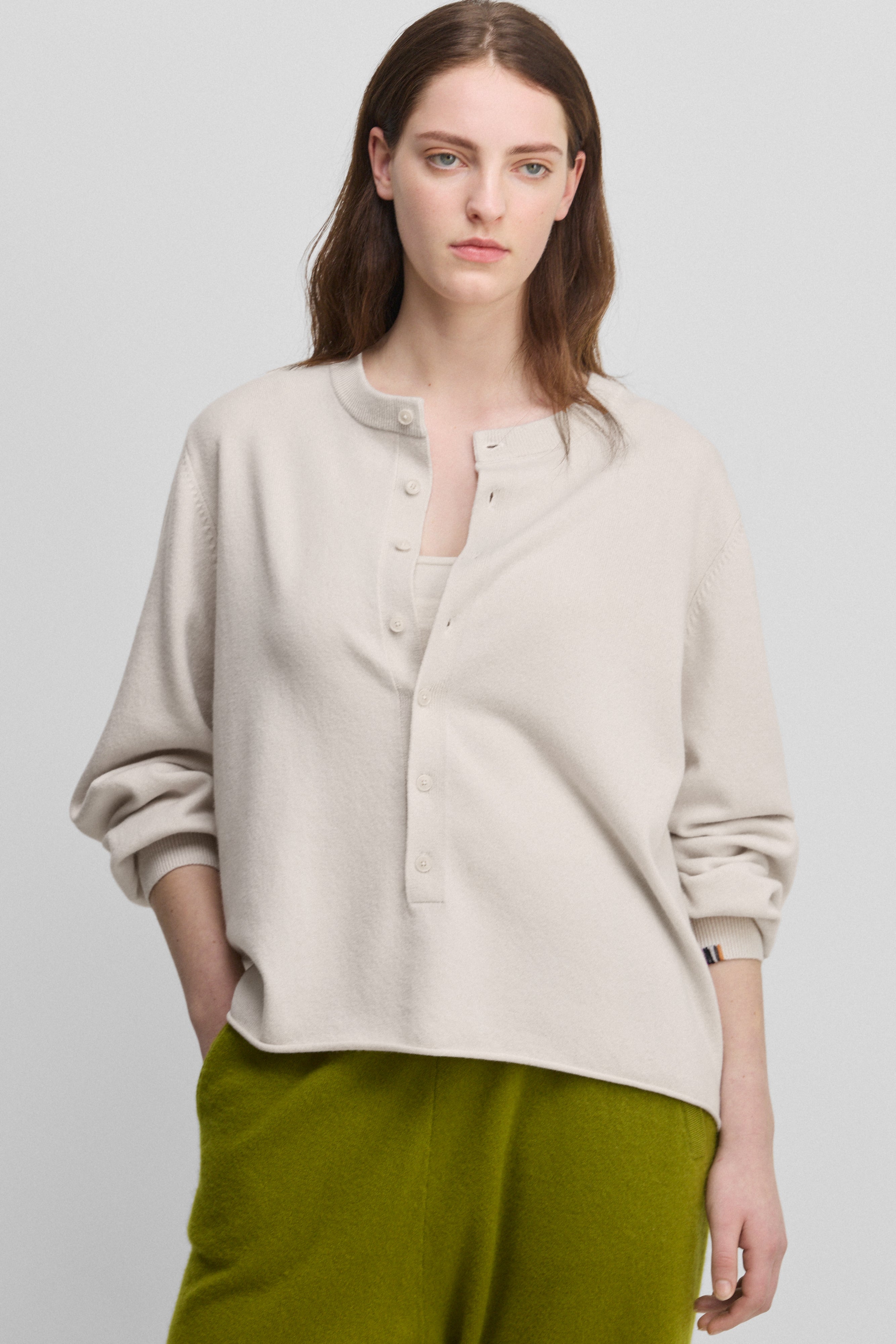 woman wearing a white relaxed-fit cashmere sweater with corozo buttons.