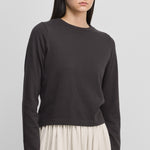 woman wearing a dark grey long-sleeved cotton cashmere crewneck t-shirt.