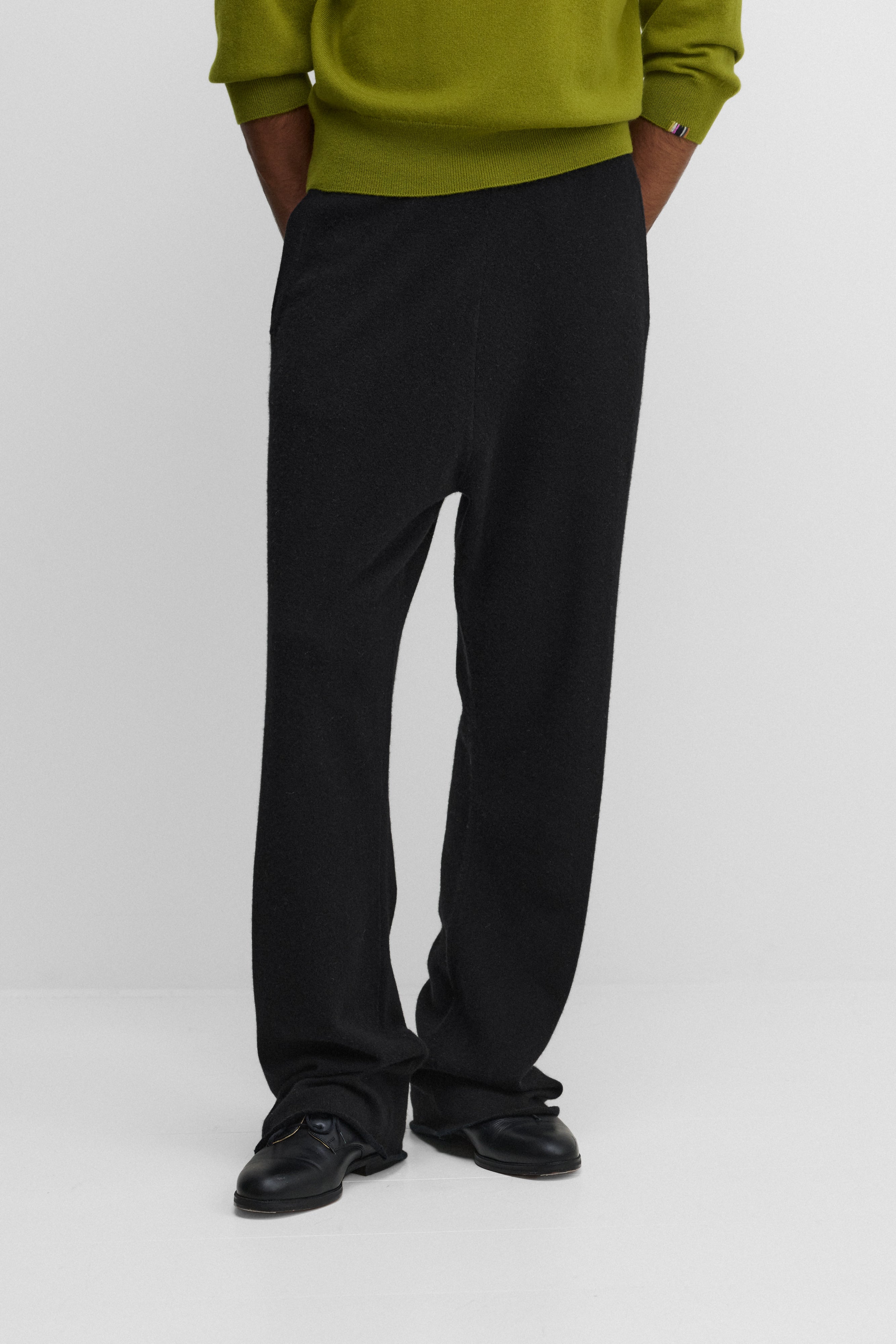 model wearing black loose-fit cashmere pants with two side pockets and a drawstring.