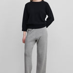woman wearing light grey rib-knit cashmere pants with straight legs and a drawstring waist.