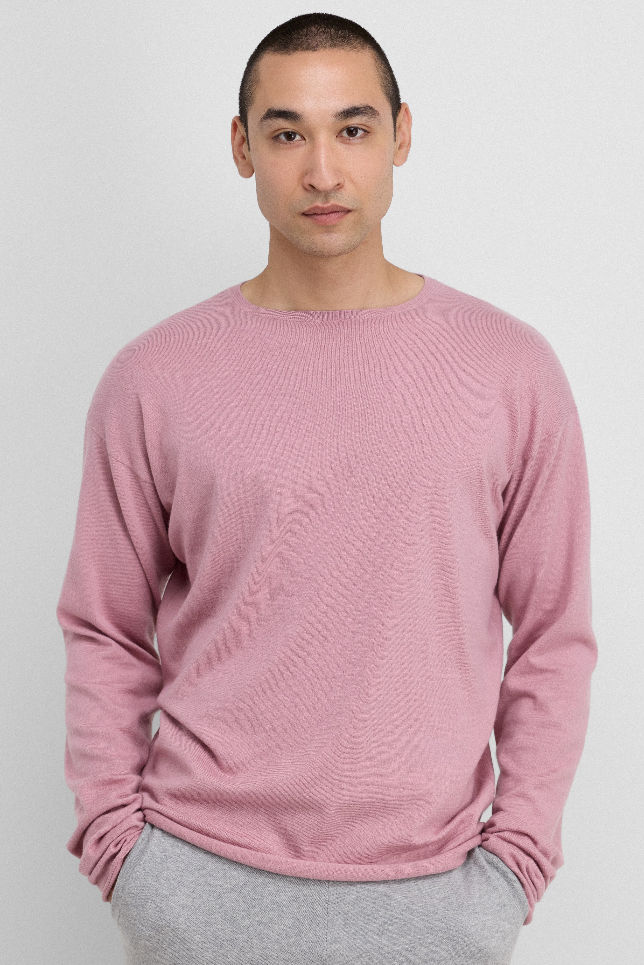 man wearing a relaxed-fit pink cotton-cashmere long-sleeved top with a crew neck.