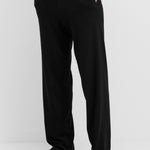 man wearing loose-fit black cotton cashmere pants with side pockets and drawstring waist.