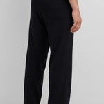 woman wearing loose-fit black cotton cashmere pants with one back pocket, shown from the back.