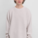 man wearing a white ribbed cashmere crew-neck sweater.