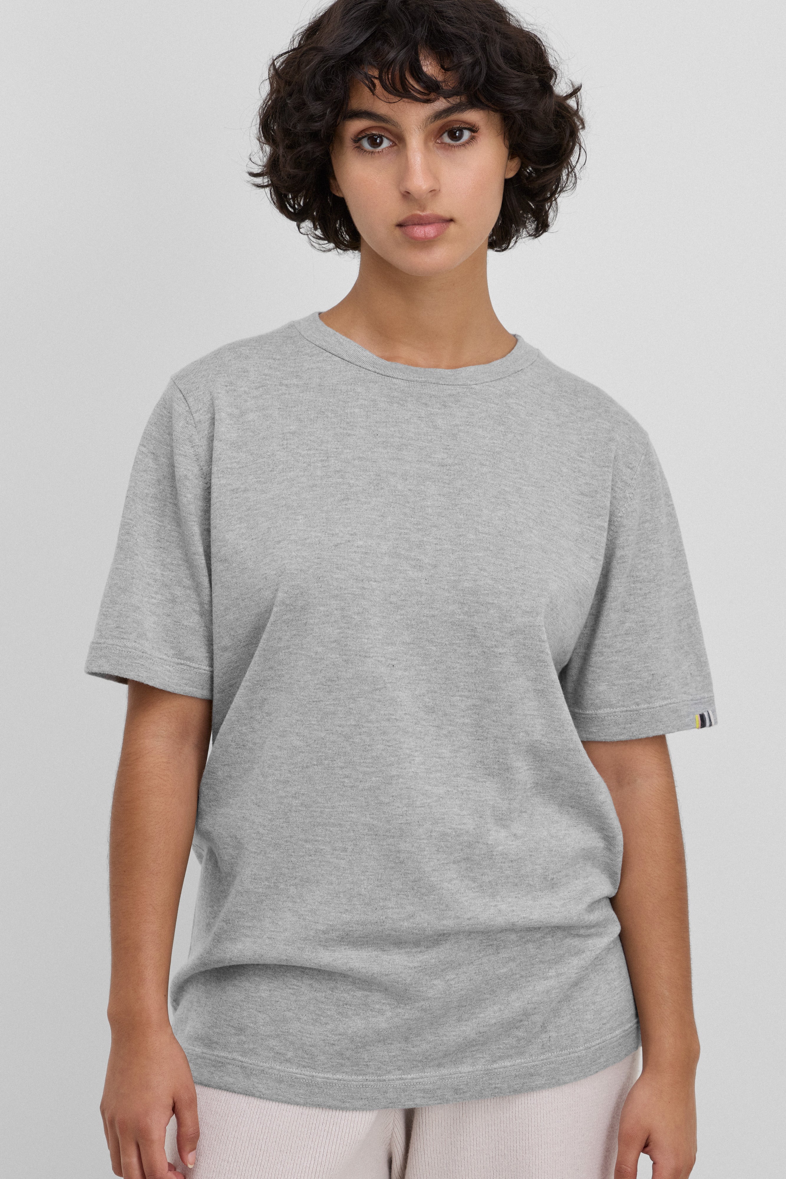 woman wearing a light grey short-sleeved cotton cashmere crewneck t-shirt.