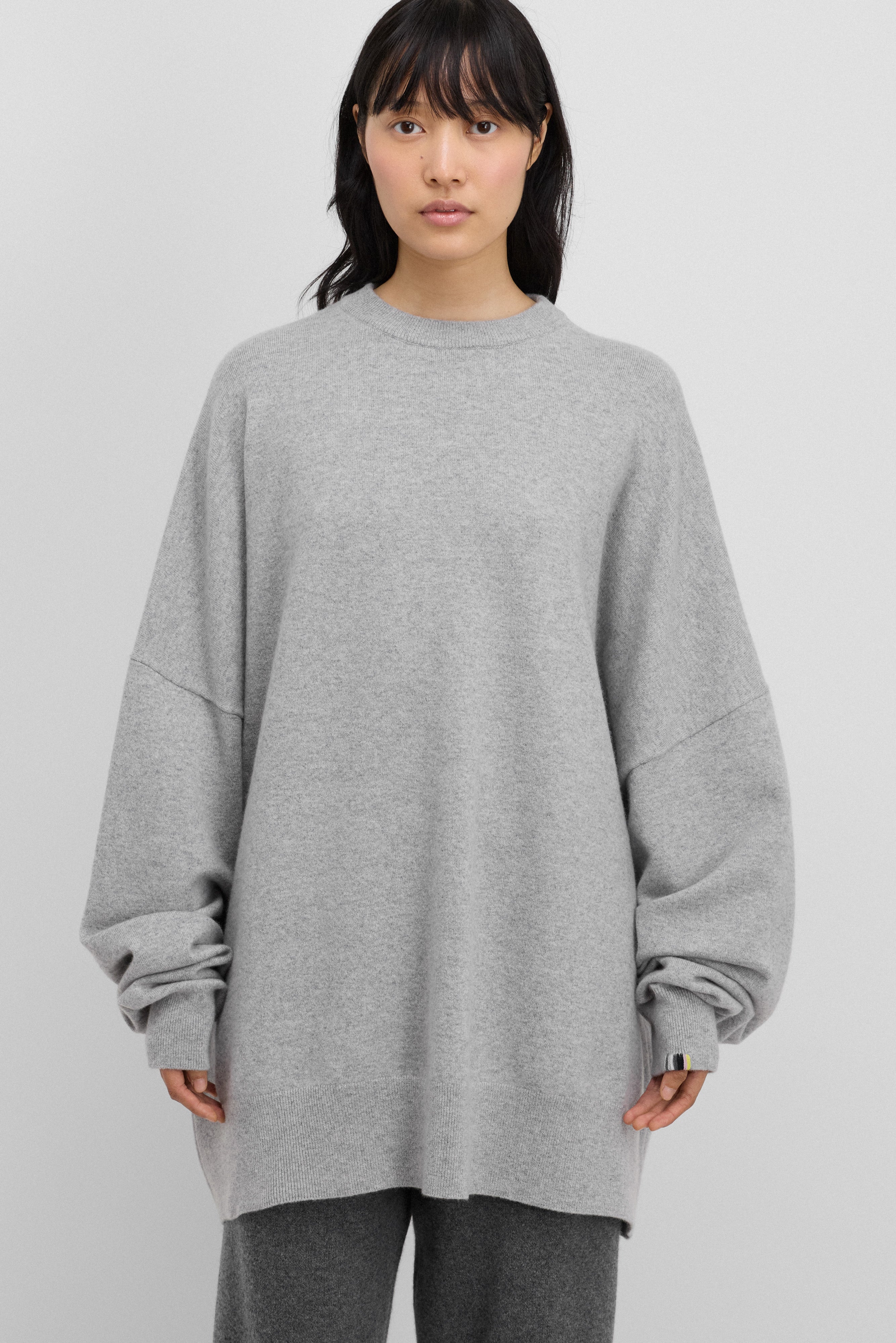 woman wearing an oversized grey cashmere crewneck sweater with long sleeves and ribbed trims.