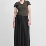 woman wearing a black cotton cashmere maxi skirt with an elastic waistband and side pockets.