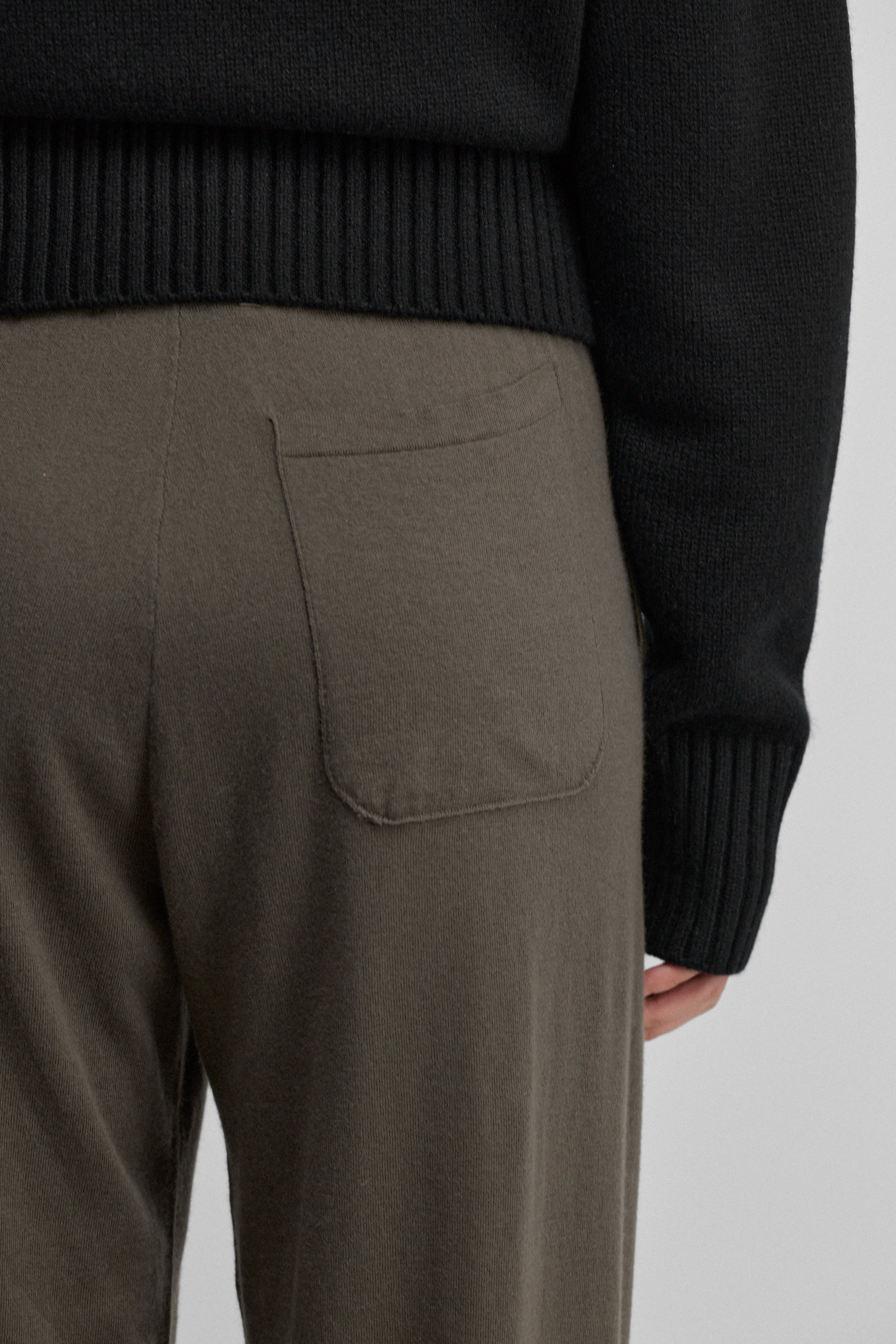 detail of the back pocket of army green cotton cashmere pants.