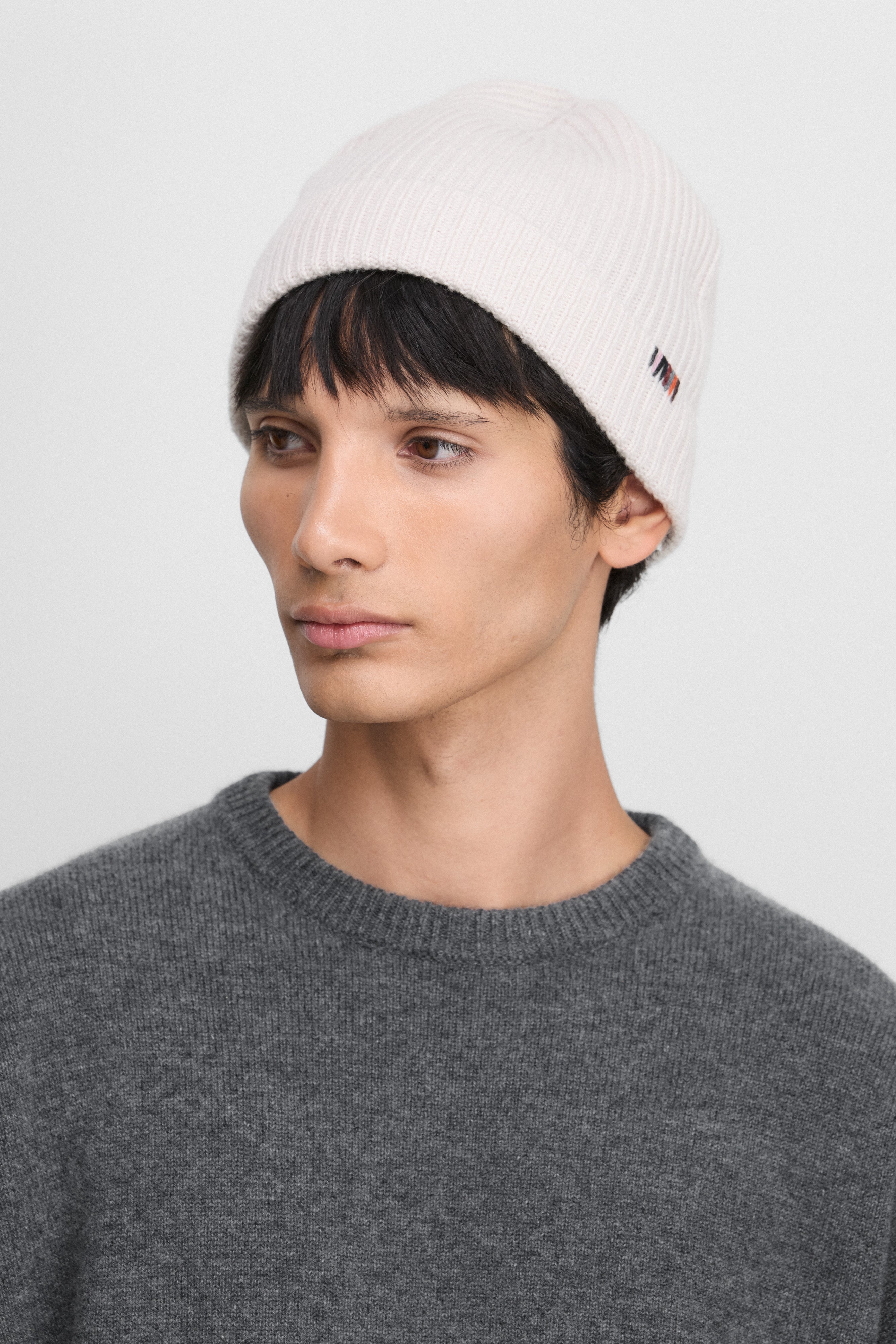 man wearing a white cashmere rib-knit beanie.