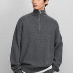 man wearing a dark grey quarter-zip cashmere sweater with drop shoulder and ribbed trims.