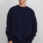 man wearing a navy blue relaxed-fit cashmere crew-neck sweater in a heavy knit.