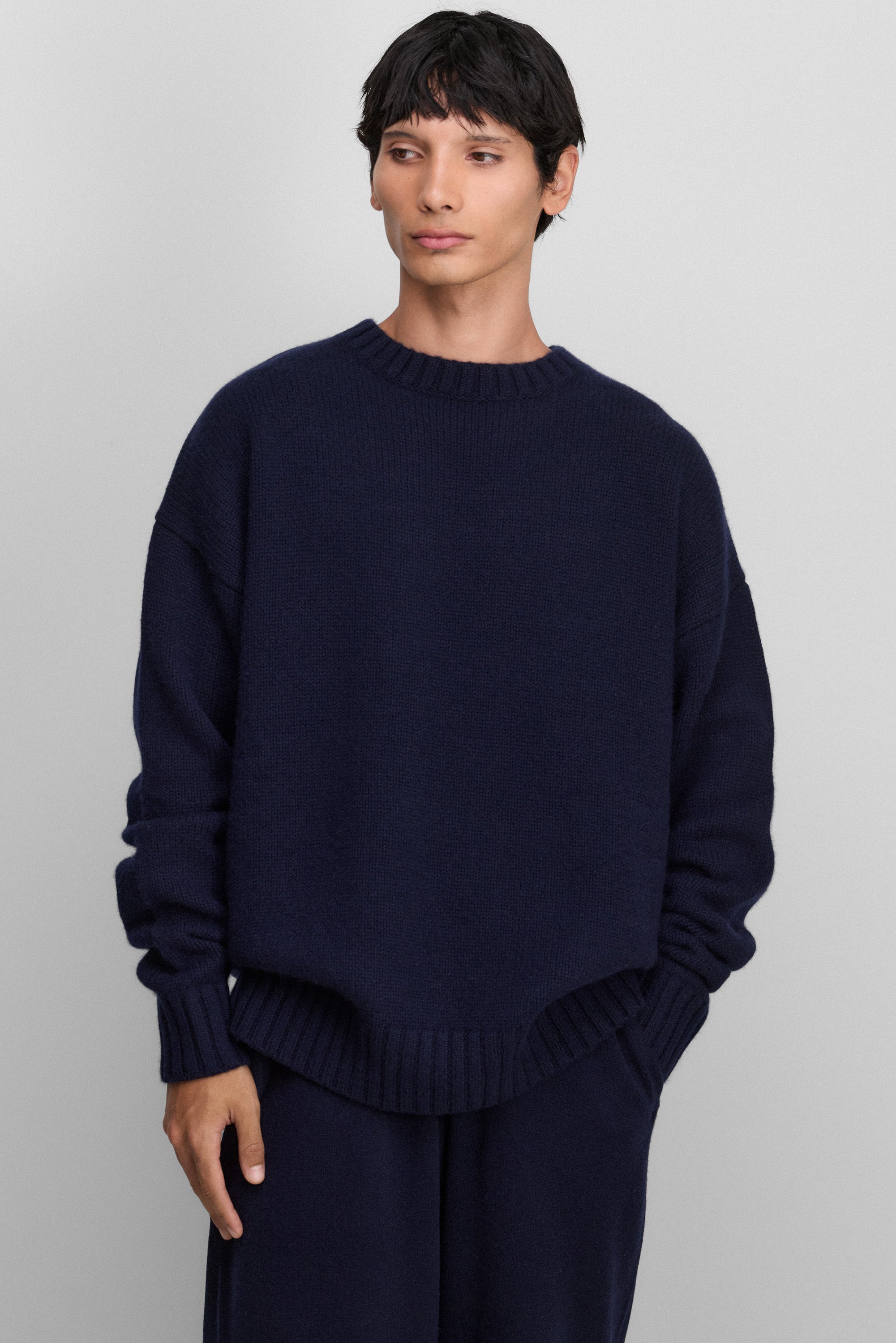 man wearing a navy blue relaxed-fit cashmere crew-neck sweater in a heavy knit.
