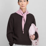 woman wearing a dark brown cashmere crew-neck sweater, styled with a pink scarf.