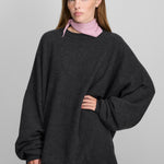 woman wearing an oversized dark charcoal grey cashmere crewneck sweater with long sleeves and ribbed trims.