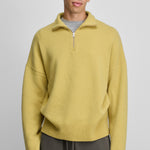 man wearing a yellow quarter-zip cashmere sweater with drop shoulder and ribbed hem and cuffs.