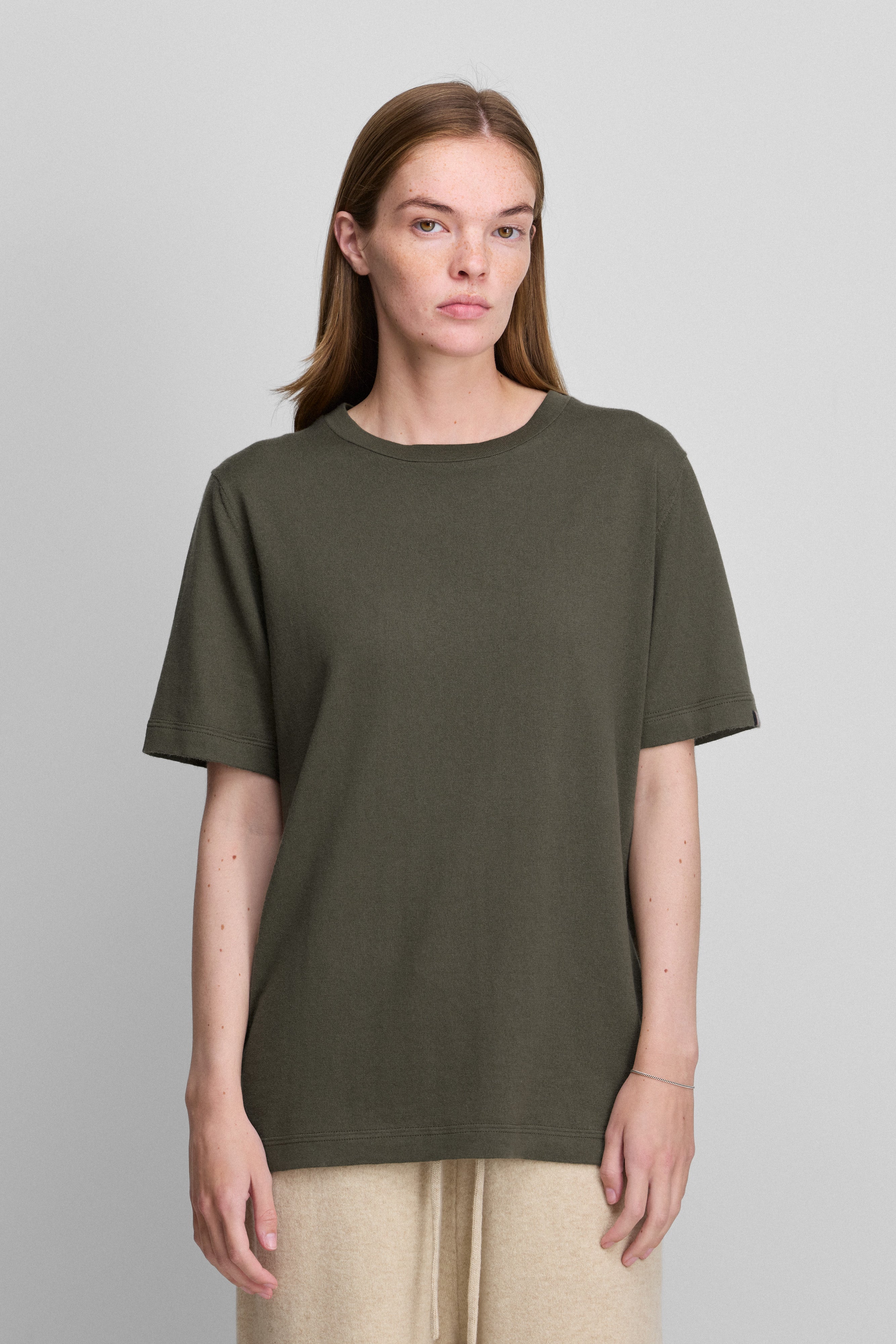 woman wearing an army green short-sleeved cotton cashmere crewneck t-shirt.