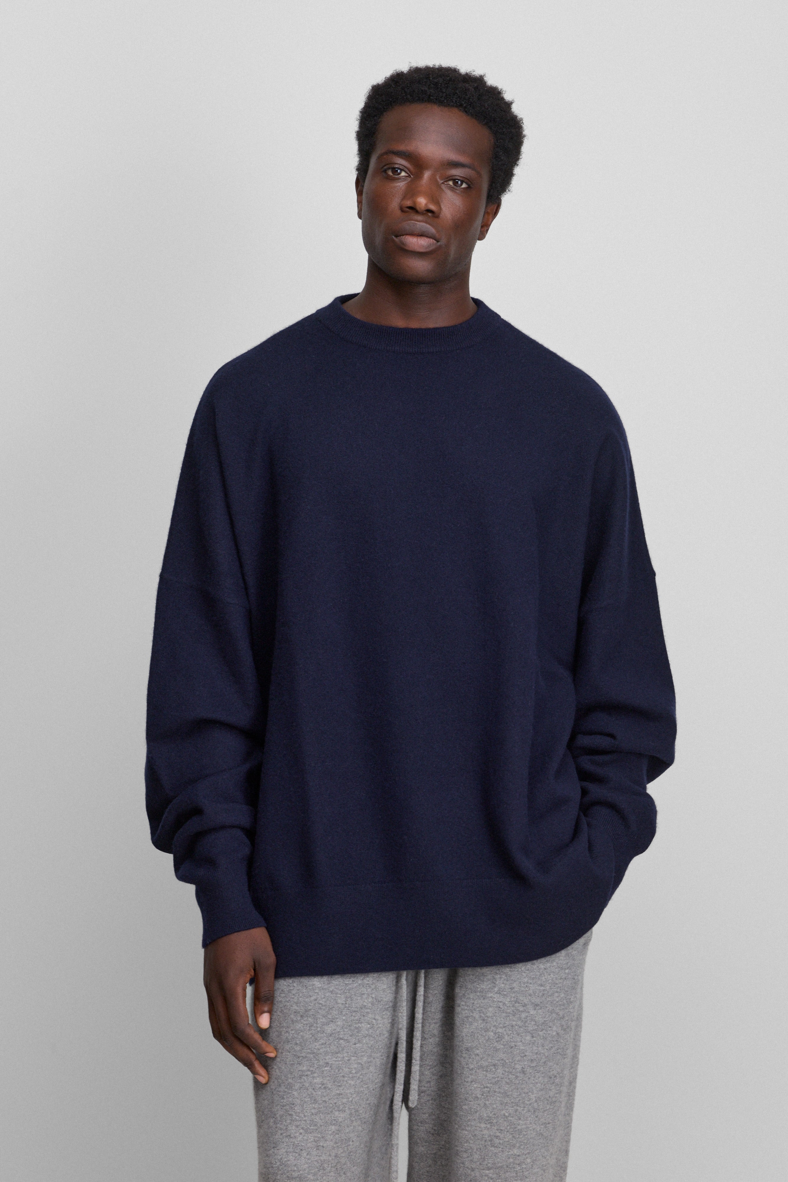 man wearing an oversized navy blue cashmere crewneck sweater with ribbed trims.