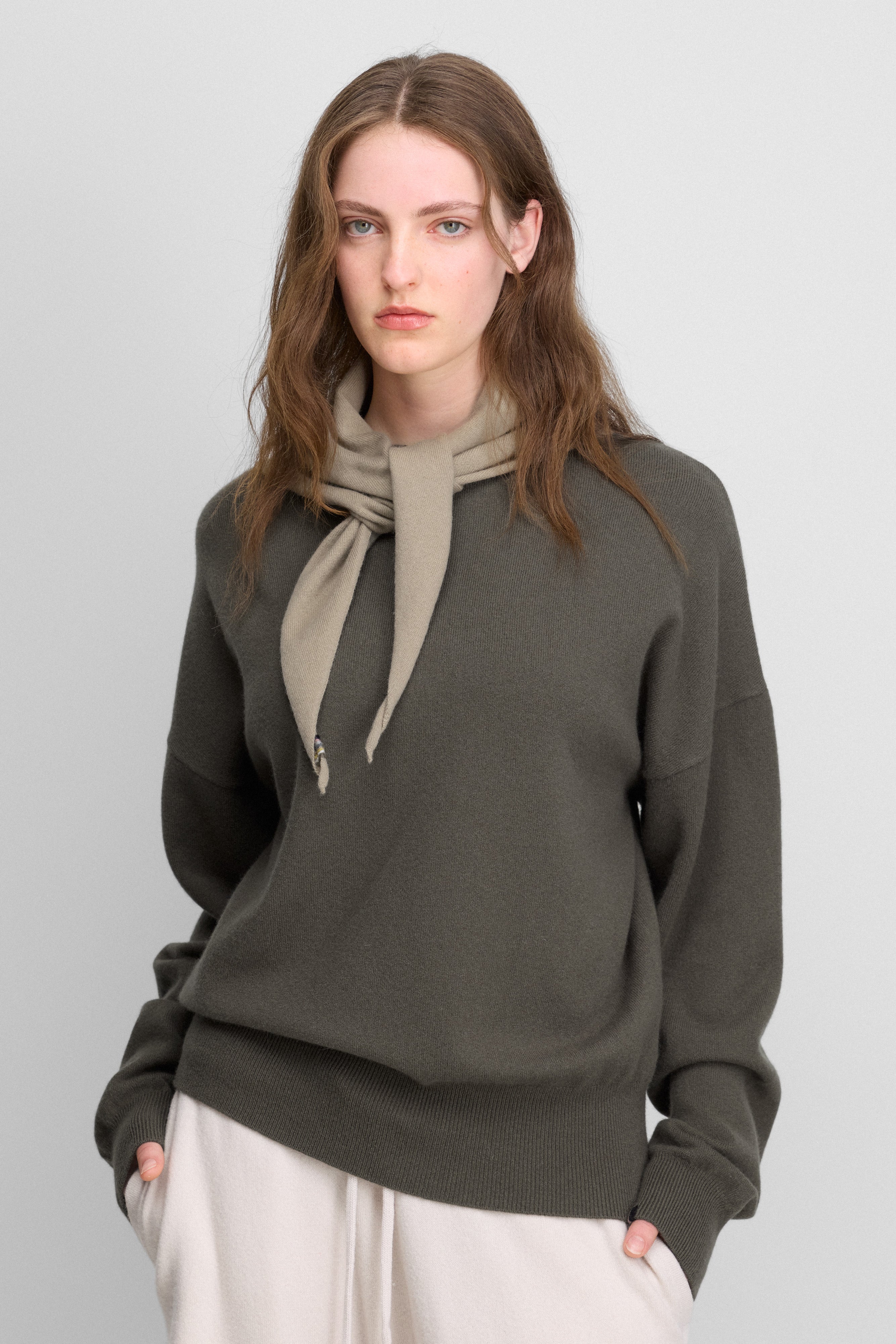 woman wearing an oversized olive green cashmere sweater with rib-knitted hem and cuffs.