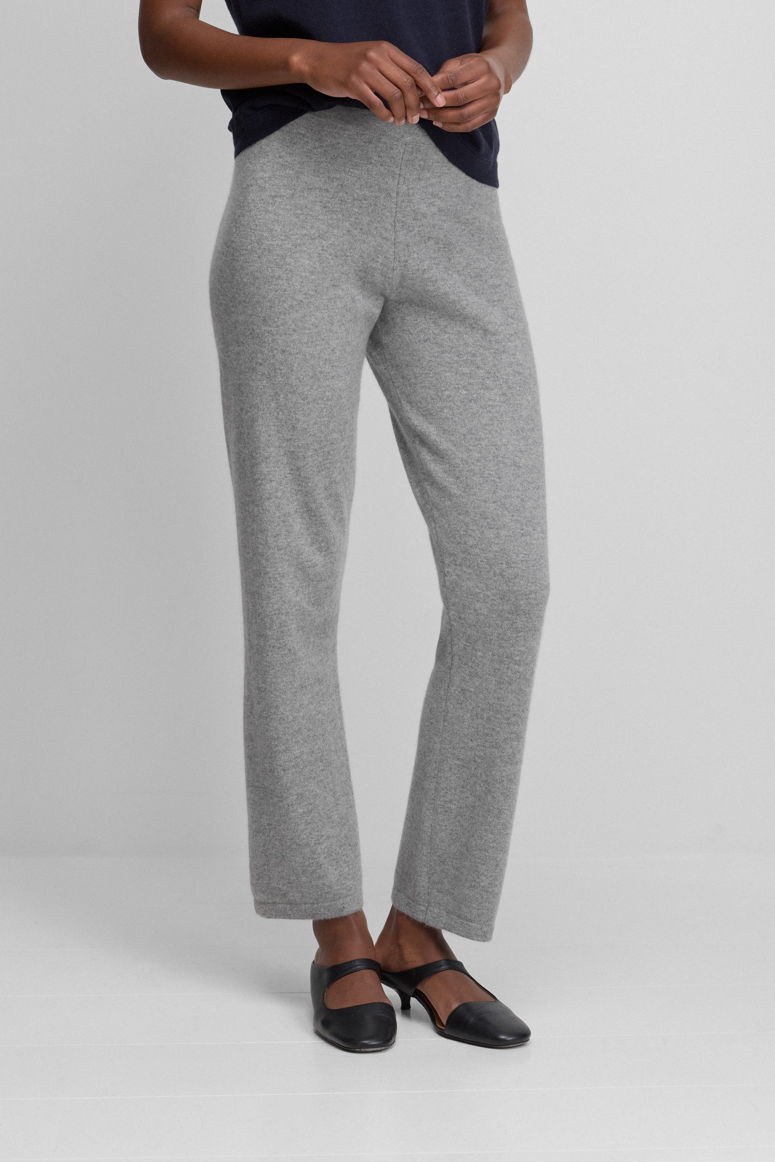 woman wearing grey petite cashmere pants with straight cropped legs and elastic waistband with drawstring.