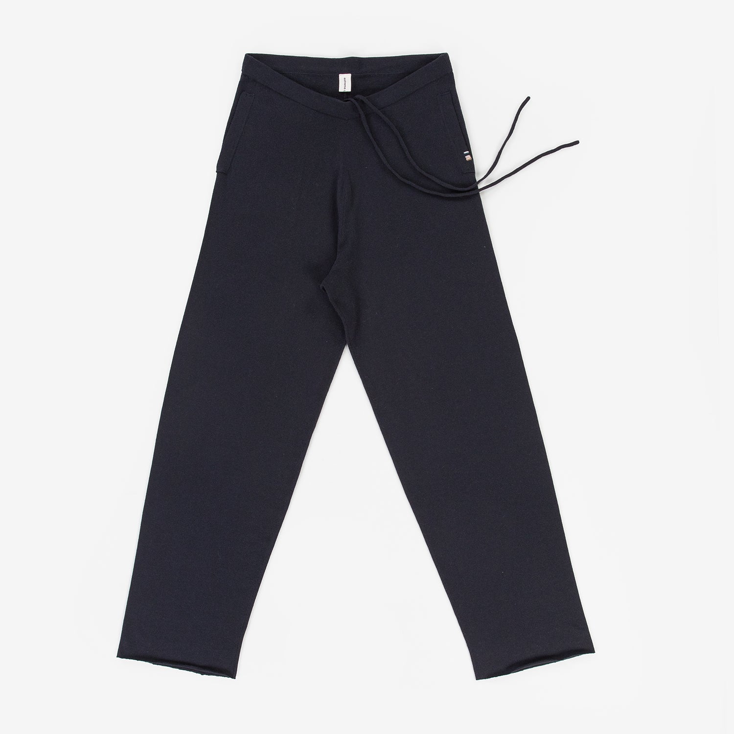 navy blue cotton cashmere pants with side pockets and a drawstring waist, laid flat.